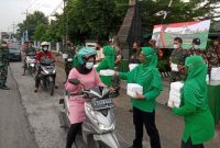 Tampak sejumlah Anggota TNI Koramil 0814/13 Peterongan Jombang, ketika membagi ratusan bingkisan takjil untuk pengguna jalan. Foto : Fa'iz