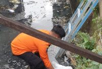 Saat petugas BPBD mengevakuai jasad bayi yang dibuang di sungai jemur ngawinan, Wonocolo, Surabaya, (foto: Ady_Kicom)