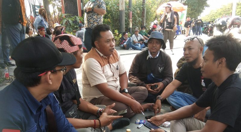 Suasana Para Demontran dari Kelompok AWP saat menunggu hasil sharing korlap perwakilan aksi demo dengan pihak Mapolda Jatim, di depan Kantor Mapolda Jatim,  Kamis (23/06/2022).