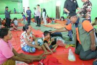 Deputi Logpal BNPB Lilik Kurniawan (kanan) menyapa warga pengungsi terdampak Gunungapi Ibu di Desa Tonguti Ternate, Halmahera Barat, Maluku Utara, Jumat (17/5).